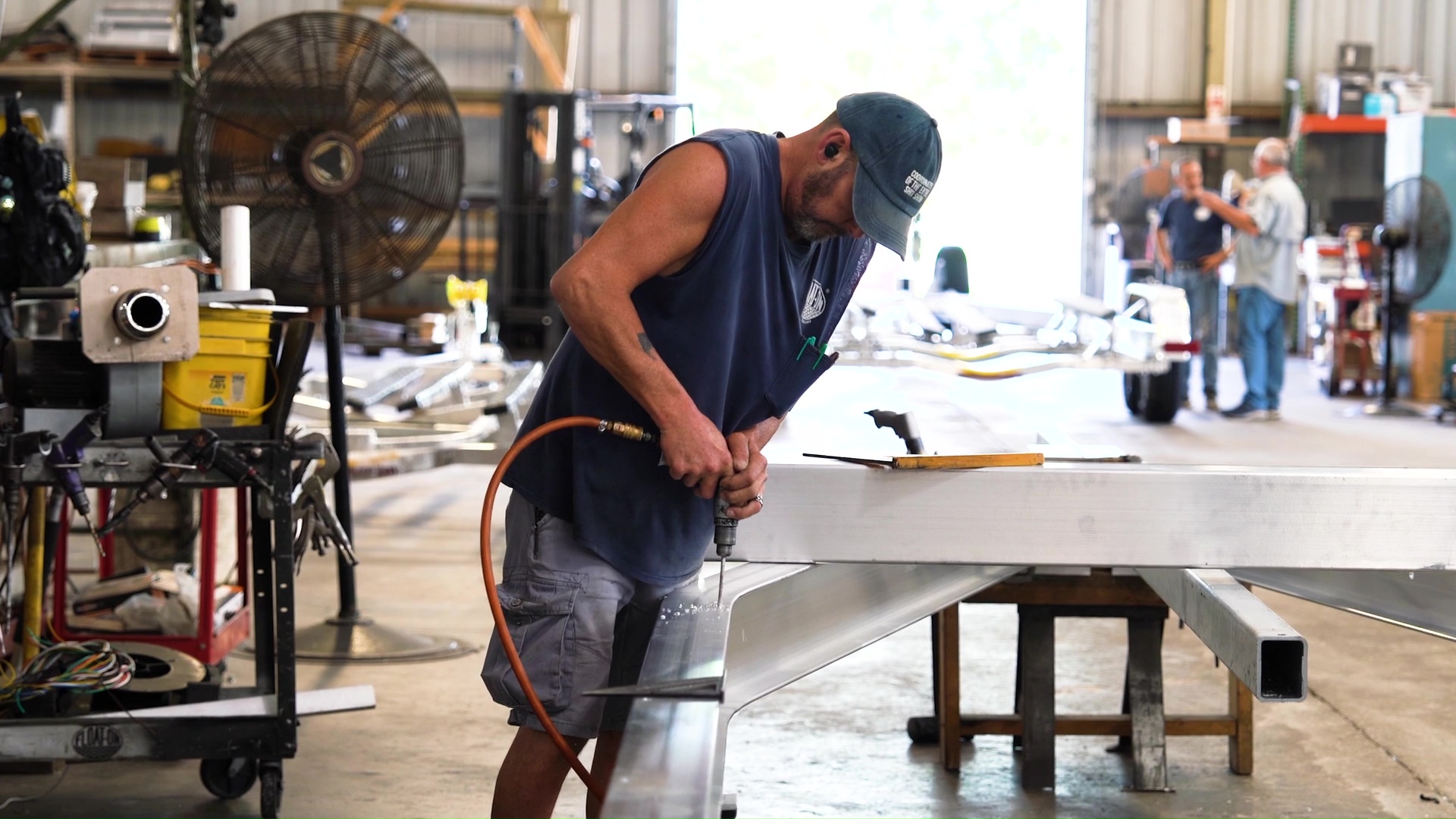 man drilling a sheet of metal